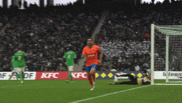 a soccer game is being played in front of a kfc ad