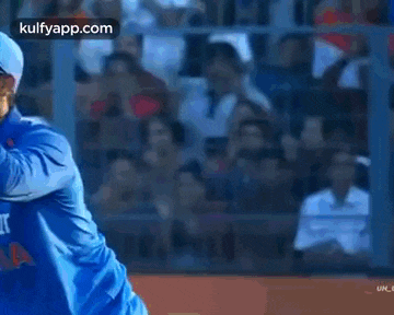 two cricket players are hugging each other while wearing blue jerseys .
