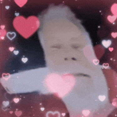 a close up of a person surrounded by hearts with their eyes closed