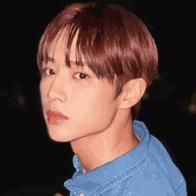 a close up of a young man with red hair wearing a blue shirt and red lipstick .