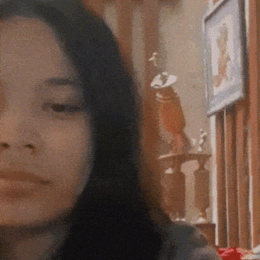 a close up of a woman 's face with a picture of a trophy in the background