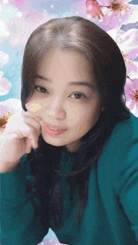 a woman in a blue shirt is surrounded by pink and white flowers