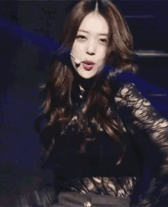 a woman in a black dress is waving her hand