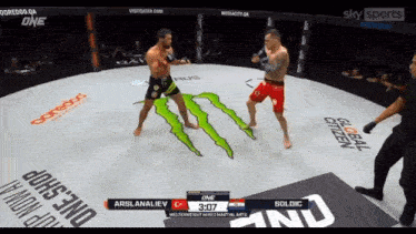 two men are fighting in a ring with a monster logo