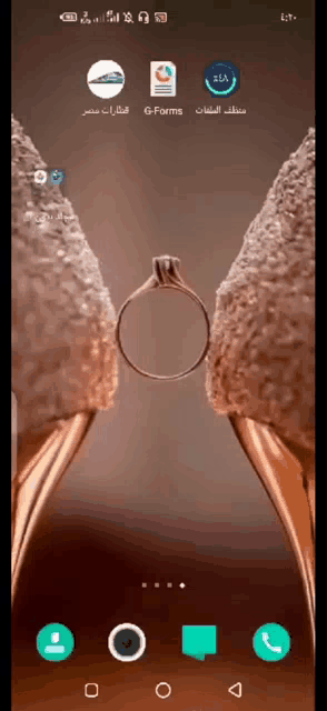 a phone screen shows a picture of a bride and groom 's wedding shoes with a wedding ring in the middle