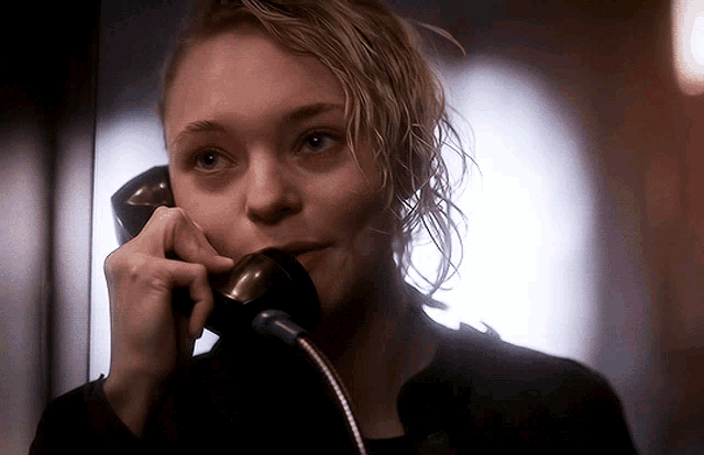 a woman is talking on a phone with a microphone