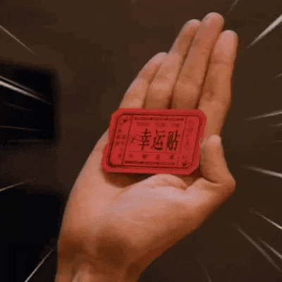 a person is holding a red ticket in their hand with chinese writing on it