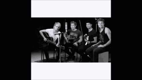 a group of young men are posing for a photo and one of them is wearing a nirvana shirt