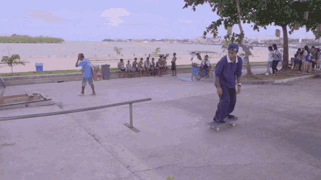 a man in a blue shirt is riding a skateboard down a ramp