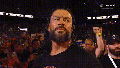 a wrestler is holding the wwe world heavyweight championship belt in a ring .