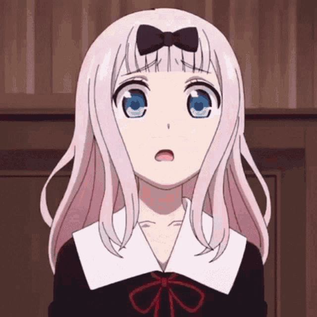 a girl with pink hair and blue eyes is wearing a black and white uniform with a bow on her head .