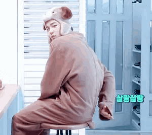 a man in a teddy bear costume sits on a stool