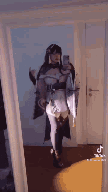 a woman is taking a selfie in front of a mirror while wearing a costume .