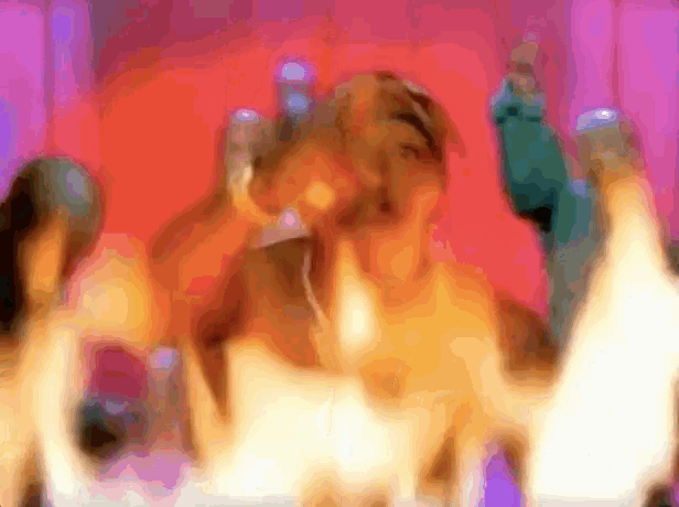 a blurry picture of a group of people dancing with flames coming out of them