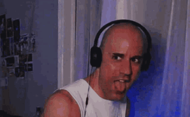 a bald man wearing headphones and a white shirt