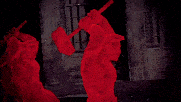 a red cloth is being blown in the wind with a shadow of a building in the background .