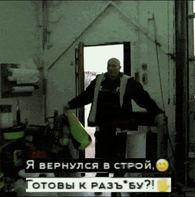 a man in a black jacket is holding a yellow bag in a garage