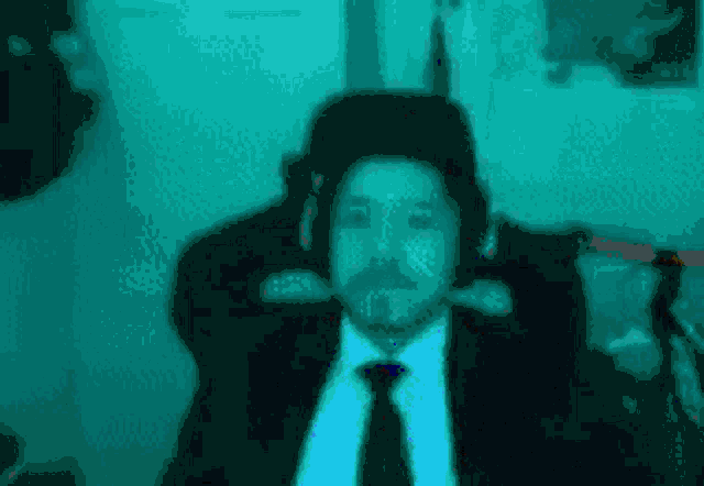 a man in a suit and tie is sitting in a chair with headphones on his head .