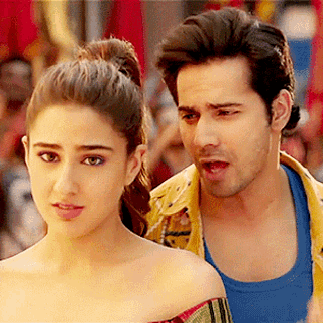 a man and a woman are standing next to each other . the woman is wearing a ponytail .