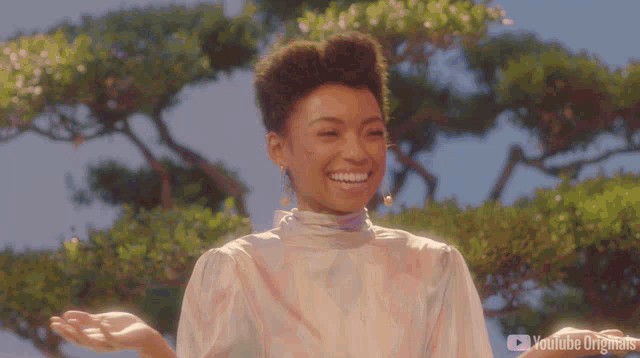 a woman is smiling in front of a tree with youtube originals written on the bottom