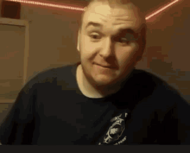 a man with a beard is making a funny face while wearing a black shirt .