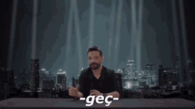 a man sitting at a desk with the word -geç written on the table