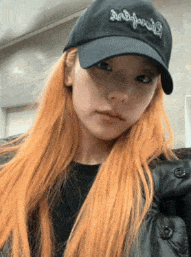 a woman with long blonde hair wearing a black hat that says ' snoop dogg ' on it