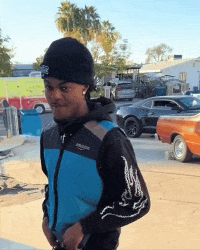 a man wearing a black beanie and a blue jacket that says amazon