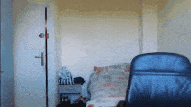 a bedroom with a bed and a chair and a door open