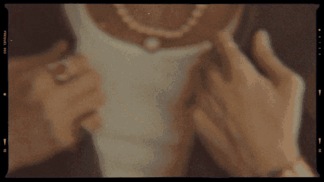 a person wearing a ring and a necklace has a film frame that says ' prosol ' on it
