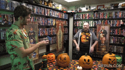 two men are standing in front of a table with pumpkins and a sign that says gifrun.com on it