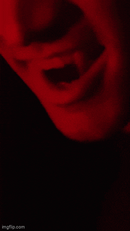 a close up of a person 's mouth with a red light behind them .