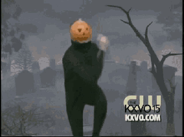 a man with a pumpkin on his head is dancing in a cemetery sponsored by kxvo 15