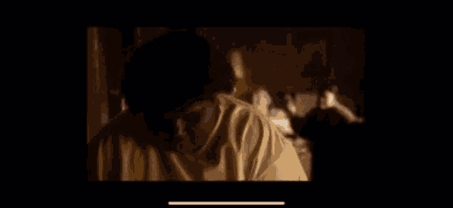 a blurry picture of a person standing in front of a window in a dark room .
