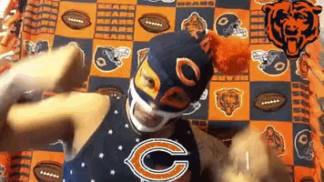 a man in a bears mask is laying on a bears blanket