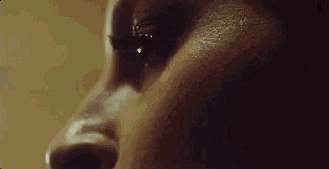 a close up of a woman 's face with tears running down her face .