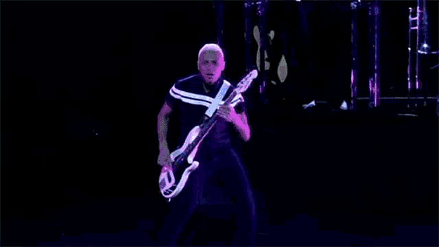 a man is playing a bass guitar on a stage