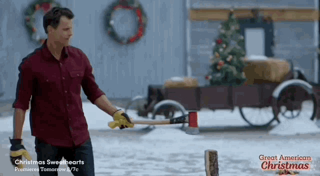 a man is holding an axe in front of a cart with a christmas tree in it .