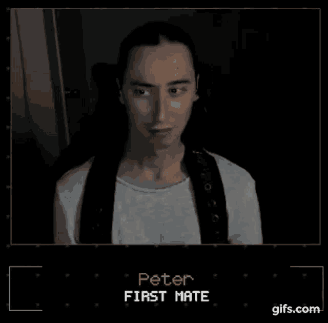a man with long hair is standing in a dark room with the words peter first mate on the screen .