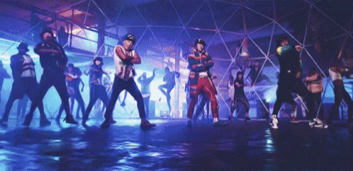a group of people are dancing in a dark room with purple lights