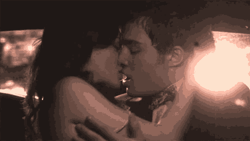 a man and a woman are kissing in a car at night .