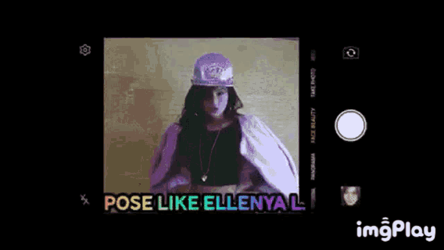 a woman wearing a purple hat is taking a picture with a camera .