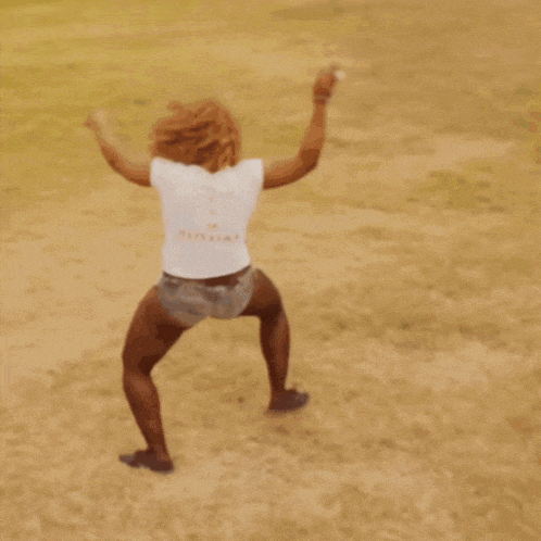 a woman in shorts and a white shirt is dancing