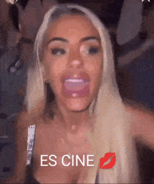 a woman with blonde hair is making a funny face with her mouth open and the words es cine on the bottom