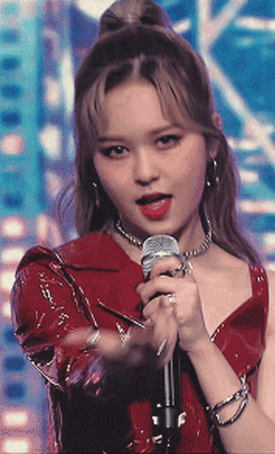 a girl in a red dress is holding a microphone