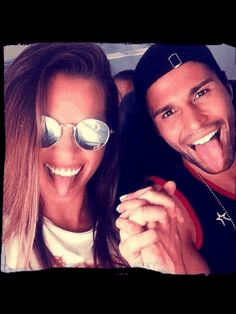a man and woman sticking their tongues out together
