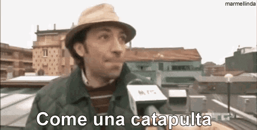 a man wearing a hat is talking into a microphone and says come una catapulta