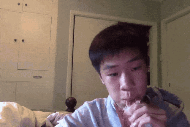 a young man smoking a cigarette in front of a door