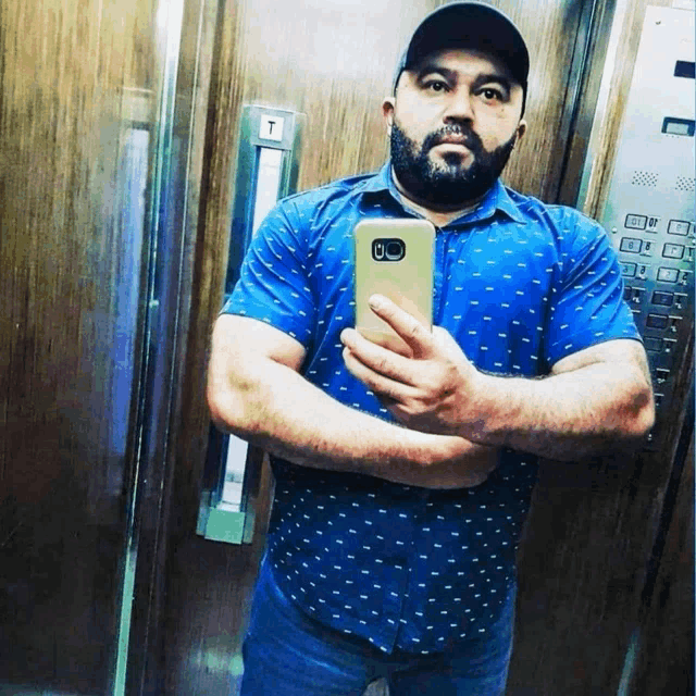 a man taking a picture of himself in an elevator with a button that says t on it