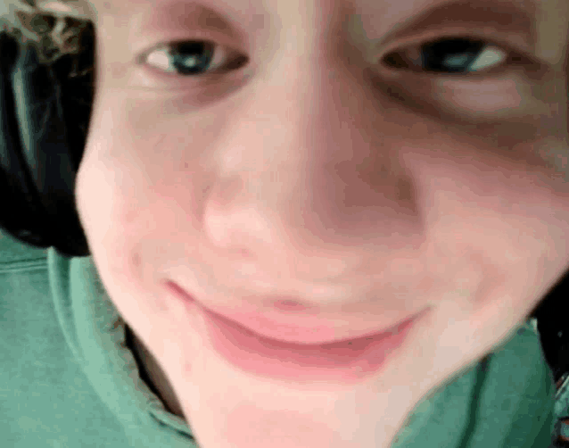 a close up of a young man 's face with headphones on .
